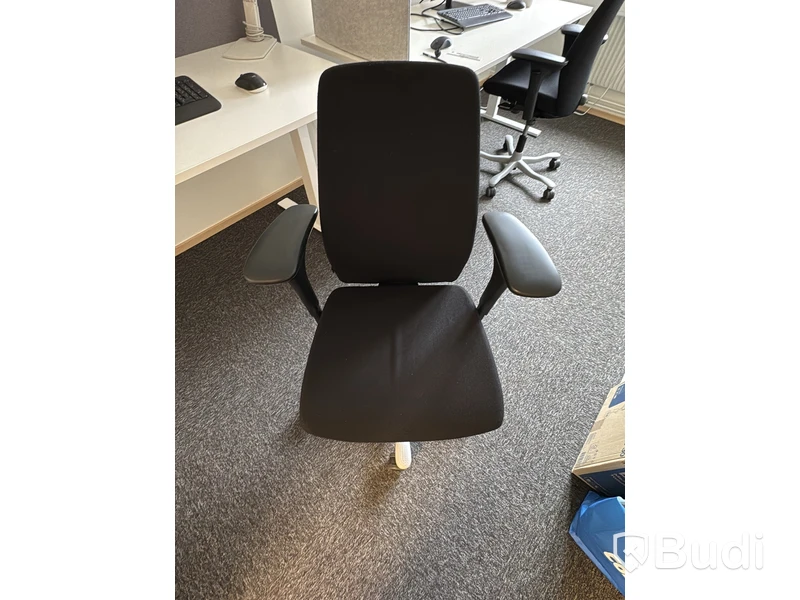 Arbetsplats med höj- och sänkbart skrivbord och kontorsstol