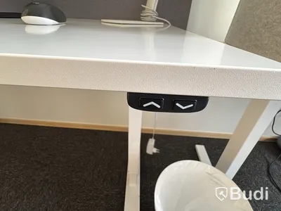 Arbetsplats med höj- och sänkbart skrivbord och kontorsstol