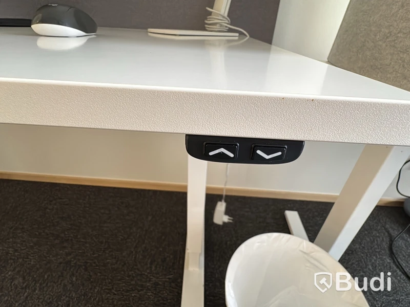 Arbetsplats med höj- och sänkbart skrivbord och kontorsstol