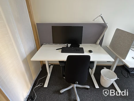 Arbetsplats med höj- och sänkbart skrivbord och kontorsstol