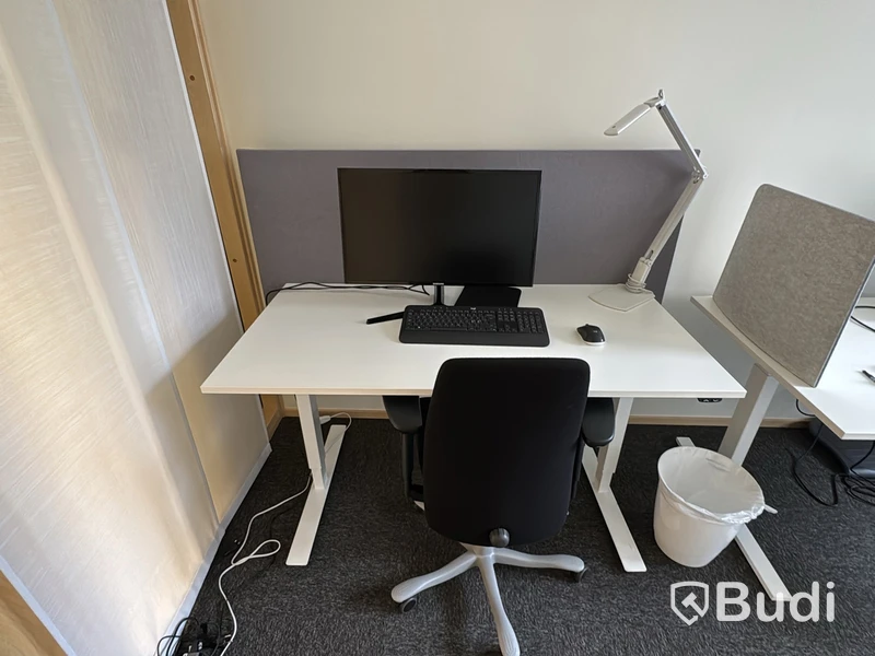 Arbetsplats med höj- och sänkbart skrivbord och kontorsstol