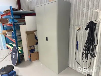 Grey metal storage cabinet with shelves and contents.
