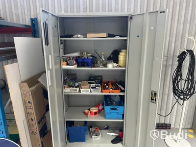 Grey metal storage cabinet with shelves and contents.
