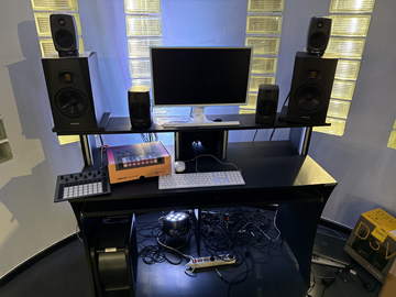 Studioskrivbord med högtalare och samplingsmaskin.