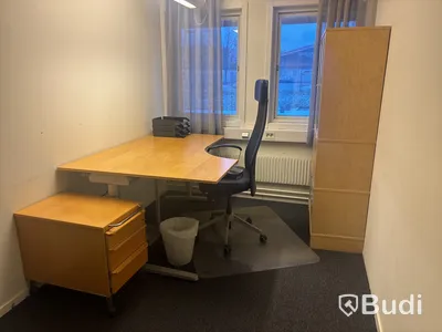 Kontorsplats med skrivbord, stol och skåp.
