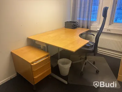 Kontorsplats med skrivbord, stol och skåp.
