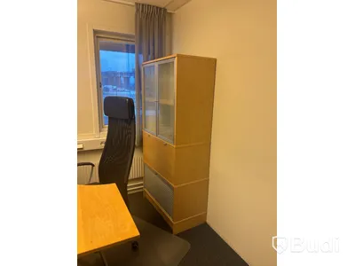 Kontorsplats med skrivbord, stol och skåp.