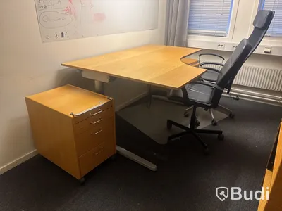 Kontorsplats med skrivbord, stol och skåp.