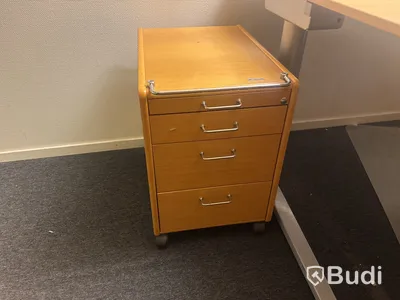 Kontorsplats med skrivbord, stol och skåp.