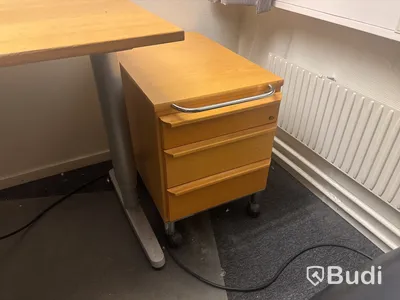 Kontorsplats med skrivbord, stol och skåp.