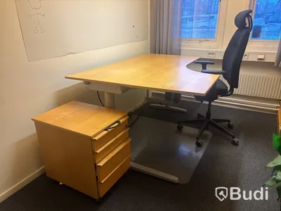 Kontorsplats med skrivbord, stol och skåp.