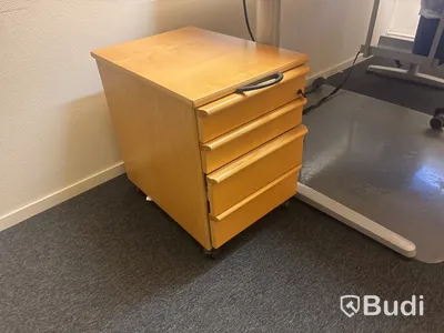 Kontorsplats med skrivbord, stol och skåp.