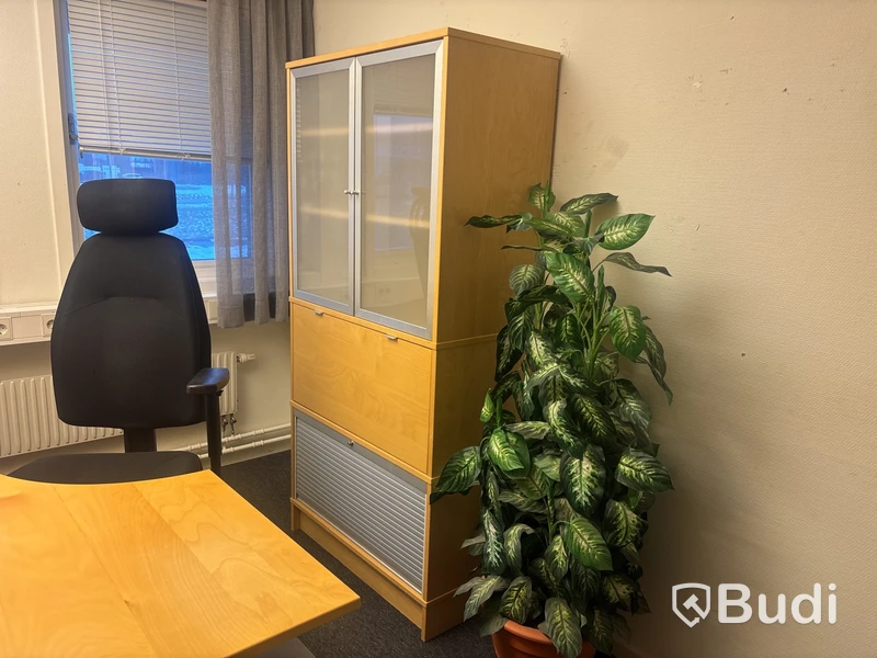 Kontorsplats med skrivbord, stol och skåp.
