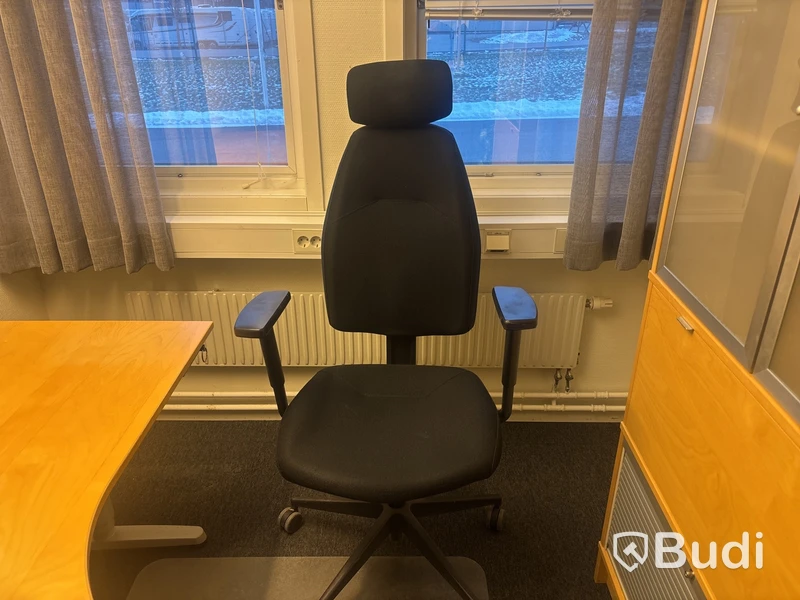 Kontorsplats med skrivbord, stol och skåp.