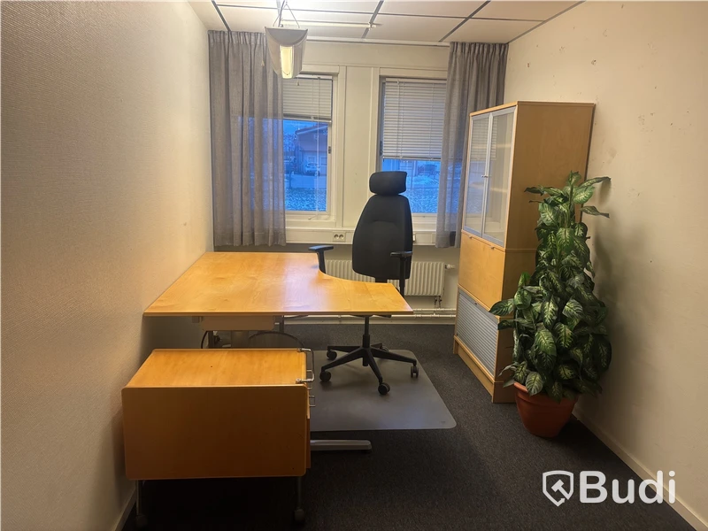 Kontorsplats med skrivbord, stol och skåp.