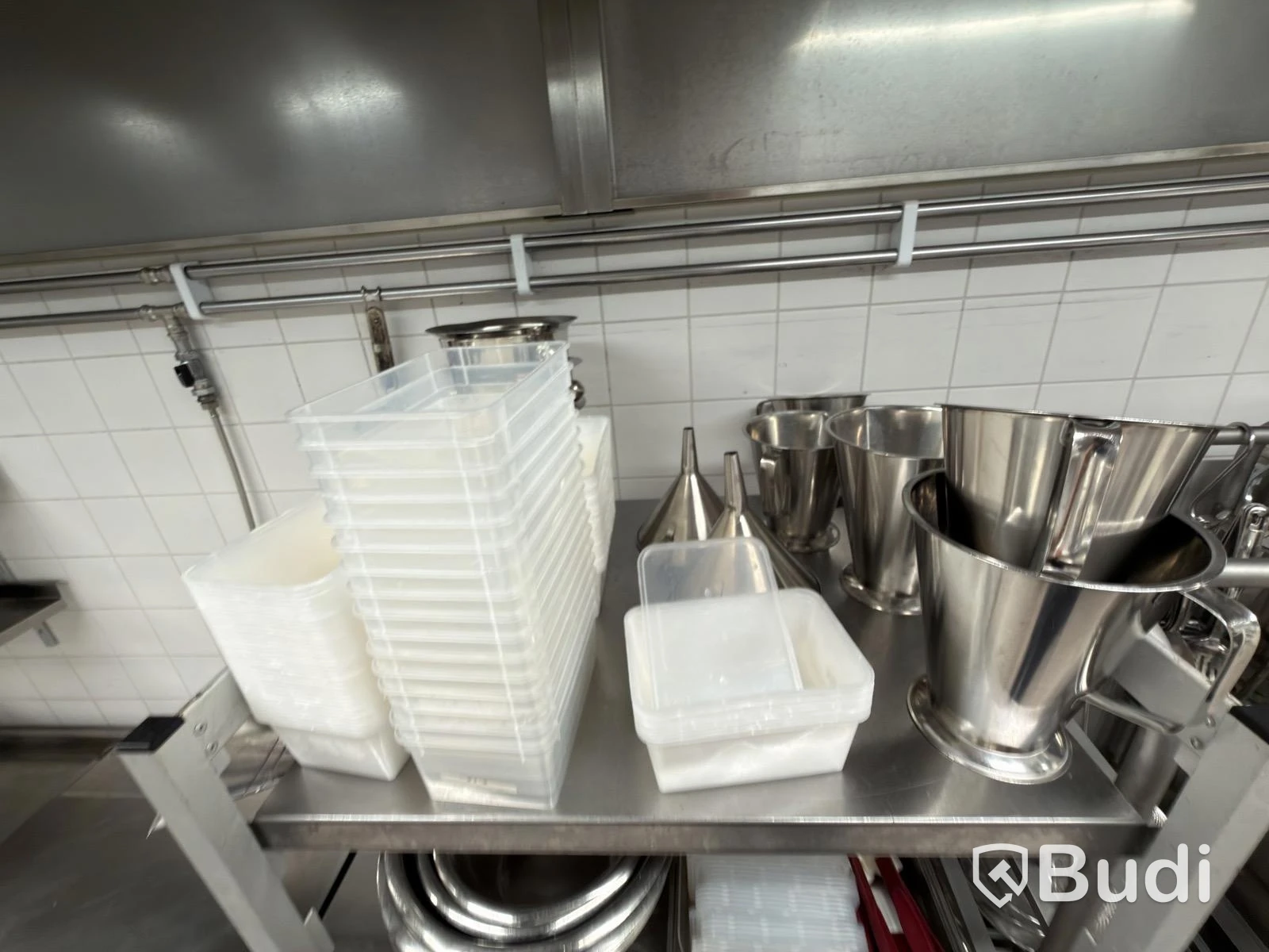 Två rostfria hyllor med Diverse rostfria blandade kökstillbehör ugn lådor
