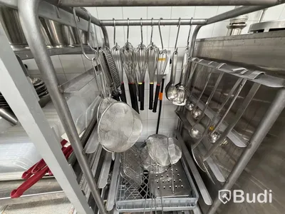 Two stainless steel shelves with assorted stainless steel kitchen accessories and oven drawers