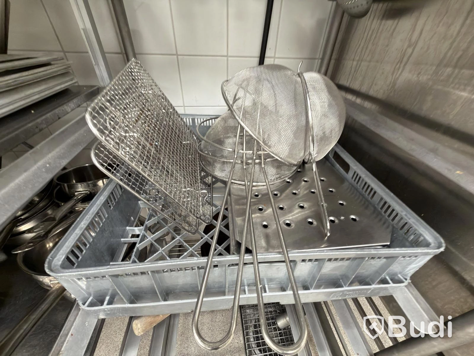 Två rostfria hyllor med Diverse rostfria blandade kökstillbehör ugn lådor
