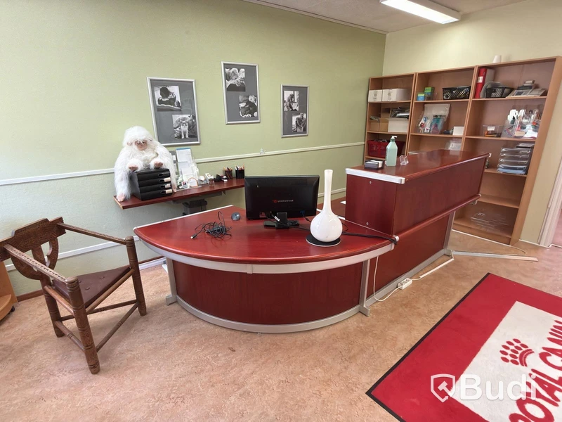 Skrivbord i receptionsutförande samt munkstol och bokhyllor