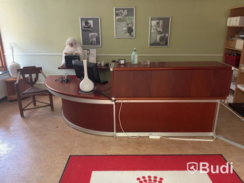 Skrivbord i receptionsutförande samt munkstol och bokhyllor