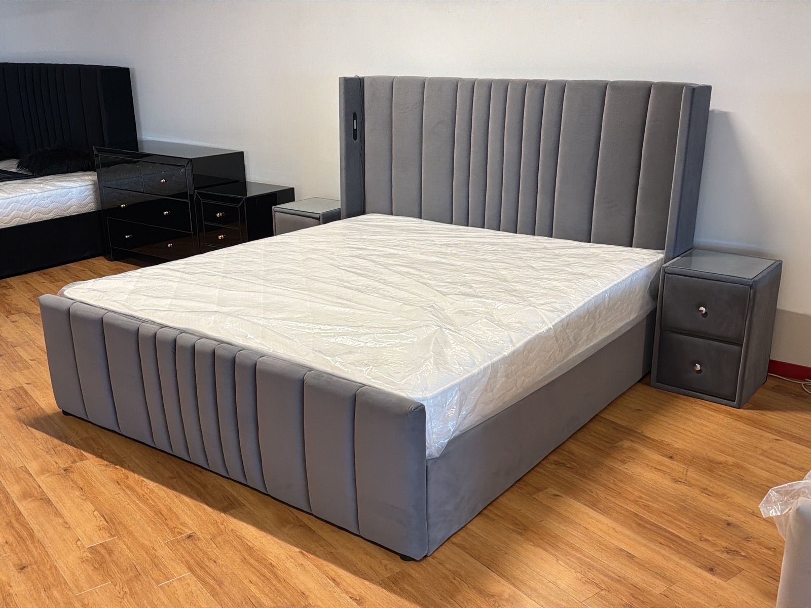 Säng 180x200 cm, med sänggavlar i grå sammet samt 2 st sängbord