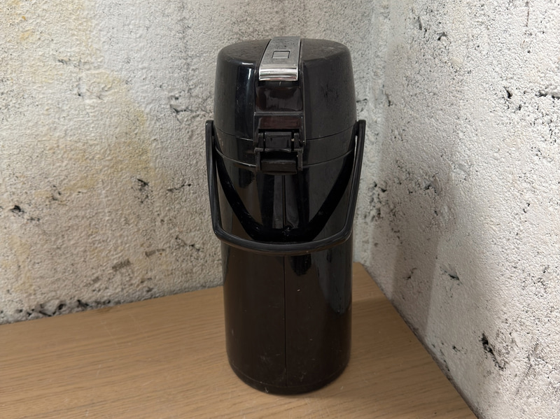 Pump-action thermos, black plastic, carrying handle