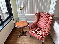 Fåtölj, sidobord och vägglampa