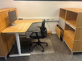 Kontorsplats med skrivbord, stol och skåp.