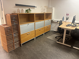 Kontorsplats med skrivbord, stol och skåp.