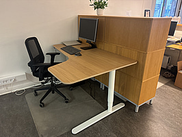 Kontorsplats med skrivbord, stol och skåp.