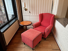 Fåtölj med fotpall, sidobord och vägglampa