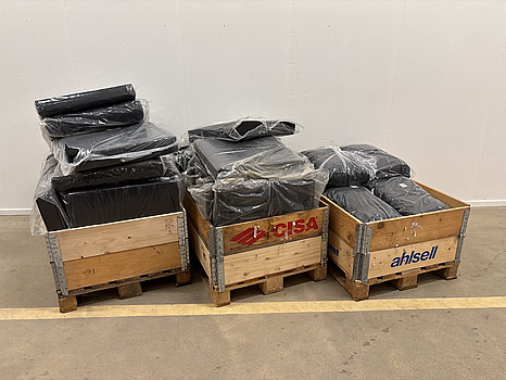 Parti med diverse dynor och kuddar till utemöbler, varierande storlekar i mörka nyanser av grått och svart