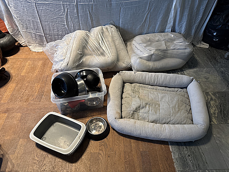 Parti med hundsängar, matskålar samt en kattlåda