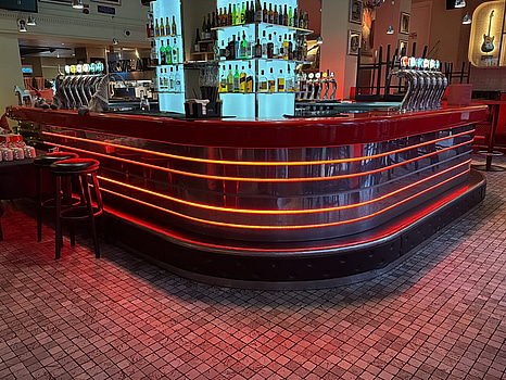 Bar i oval form med röd skiva och belysning, ca 450 x 570 cm