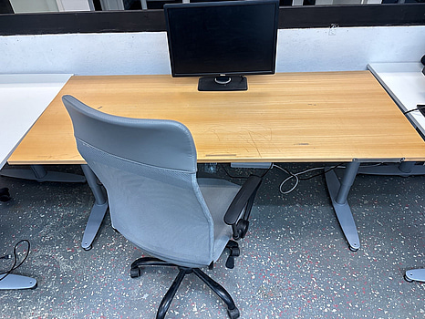 Skrivbord inkl. datorskärm och kontorsstol.
