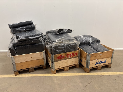 Parti med diverse dynor och kuddar till utemöbler, varierande storlekar i mörka nyanser av grått och svart